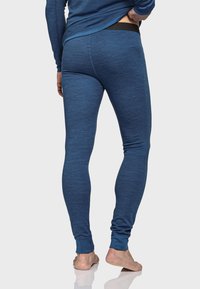 Blaue Sportleggings aus einem weichen, strukturierten Stoff. Sie haben ein körperbetontes Design und einen schwarzen elastischen Bund, der bis zum Knöchel reicht.