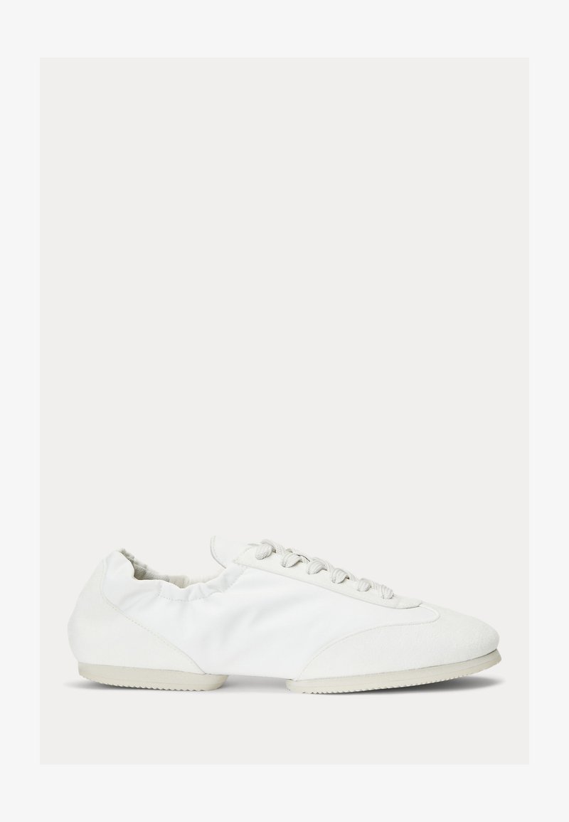 Balti žemi sportiniai batai su raišteliais priekyje, minkštas audinio viršus, elastinis apykaklė ir reljefinė gumos pado dalis, matomi iš šono.