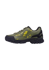 Chaussure de sport vert olive avec des accents jaunes, surface texturée, détails en maille noire et semelle extérieure noire robuste. Comprend un logo proéminent et des motifs de design.