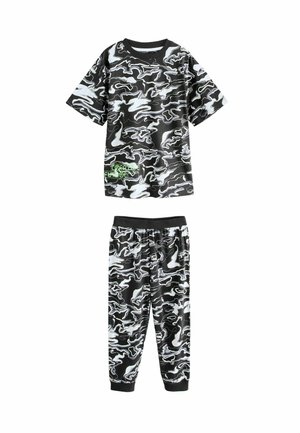 Black and white camouflage pajama set with a short-sleeve T-shirt and elastic waistband pants, featuring a reflective green logo detail.