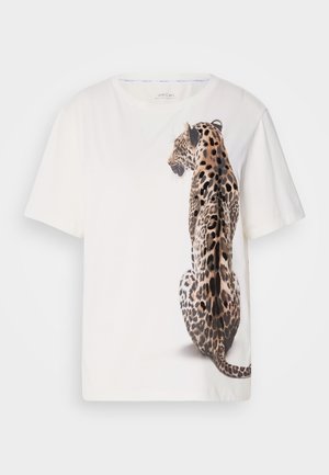 Balta trumpa rankovėmis marškinėliai, kuriuose yra išsamus leopardų grafikas šone, rodantis dėmės ir tekstūras, pagaminti iš minkštos medvilnės medžiagos.