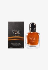 Glassflaske med ravfarget parfyme og rund svart kork. Boksen har en svart bakgrunn med oransje aksenter og hvit tekst. 30 ml størrelse.