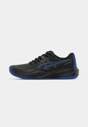 Chaussure de sport noire avec des accents bleus, dotée d'un dessus perforé, d'un bout rond et d'une semelle texturée. Comprend un design à lacets et un détail de logo.