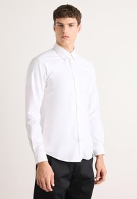 Witte lange mouwen overhemd met knoopsluiting en kraag, gemaakt van een gestructureerde stof, met een slim fit en knoopmanchetten.