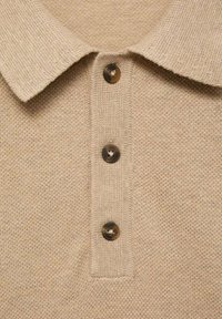Polo shirt beige in maglia con tessuto testurizzato, caratterizzato da un colletto a punta e tre bottoni marroni scuri sul davanti.
