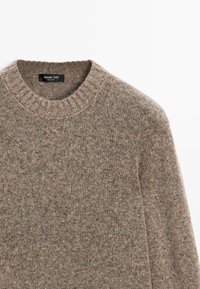 Brauner Strickpullover mit runder Halslinie, gerippten Bündchen und einer strukturierten Oberfläche. Das Etikett trägt die Aufschrift "Massimo Dutti."