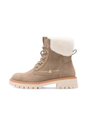 Beige mockaskinnsankelstövlett med vit pälsmanschett, snörning framtill, beige gummisula och Beverly Hills Polo Club-logga på sidan.