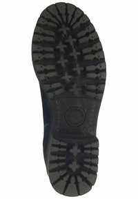 Suela de bota de goma negra con patrones de surcos profundos y características de tracción. Logo circular cerca del talón. Talla marcada como 37.