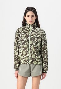 Lightweight zip-up jacket in green with a brown floral pattern, featuring a high collar and elastic cuffs, paired with gray shorts.