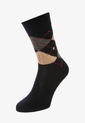 Schwarze Baumwollsocke mit einem Diamantmuster in Beige, Braun und Grau, akzentuiert mit roten Nähten und einem kleinen Logo an der Seite.