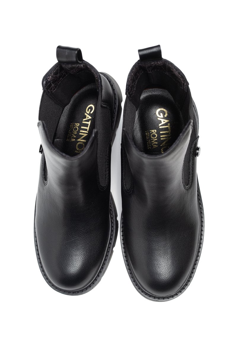 Botas de tobillo de cuero negro con paneles elásticos a los lados, diseño sin cierres, punta redonda y acentos texturizados en la parte superior. Forro interior suave.