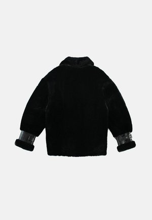 Zwarte schapenvachtjas met een hoge kraag en leren manchetten met gespsaccenten. Zachte textuur, boxy vorm en knielange ontwerp.