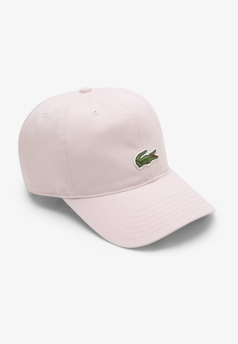 Šviesiai rožinė medvilninė beisbolo kepuraitė su išlenktu kraštu ir siuvinėta žalia krokodilo logotipu priekyje. Turi šešias dalis ir ventiliacijos skylutes.