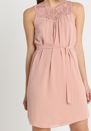 Różowa, bezrękawnikowa sukienka w odcieniu blush z kwiatową koronkową górą, plisowanym przodem i dopasowanym paskiem z tego samego materiału wiązanym w talii.
