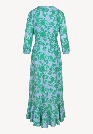 Lichtblauwe lange jurk met driekwart mouwen, groene bloemenprint, getailleerde taille en uitlopende gerafelde zoom, gezien van achteren.
