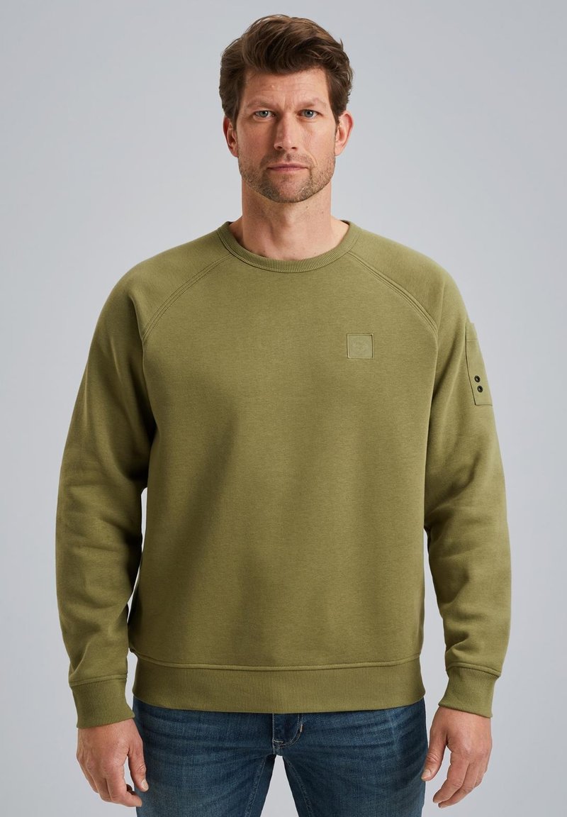 Sweatshirt vert olive avec un col rond côtelé, des manches raglan et une petite étiquette logo sur la poitrine ; texture lisse avec une coupe décontractée.