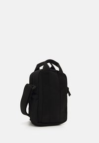 Geantă din material textil negru, cu formă rectangulară, dotată cu două mânere superioare și o curea de umăr detașabilă. Textură netedă, închidere cu fermoar, design minimalist.