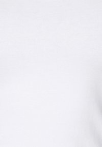Witte katoenen torso van een shirt, met een gladde textuur en een eenvoudig, minimalistisch ontwerp zonder patronen of zichtbare hardwaredetails.