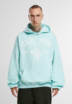 Turquoise hooded sweatshirt featuring a front kangaroo pocket, white graphic text and eagle design, loose fit, and ribbed cuffs.