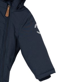 Veste à capuche pour enfants bleu marine avec fermeture éclair devant et tirette marron, montrant la manche droite avec un logo réfléchissant partiel.