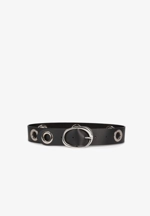 Cintura in pelle nera con design ampio, dotata di occhielli metallici e una fibbia ovale argentata, texture liscia e accenti circolari.