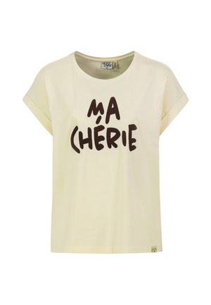 Cremefarbenes kurzärmliges T-Shirt mit umgekrempelten Bündchen und schwarzem Text "MA CHÉRIE" auf der Vorderseite.