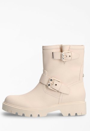 Bottines en cuir beige avec deux boucles ajustables, surface texturée, bout arrondi et semelle en caoutchouc épaisse avec un motif de traction distinct.
