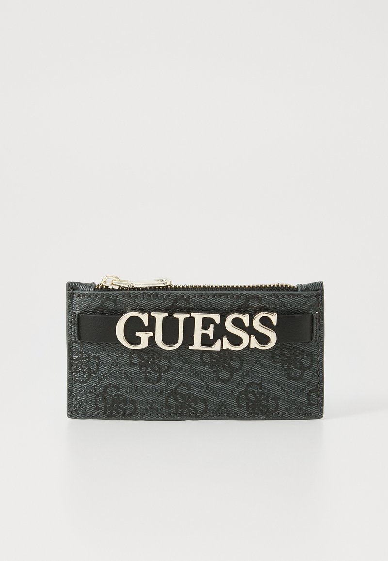 Black zippered wallet with a textured design, featuring a gold "GUESS" logo on a black strap. Smooth material with subtle patterns.