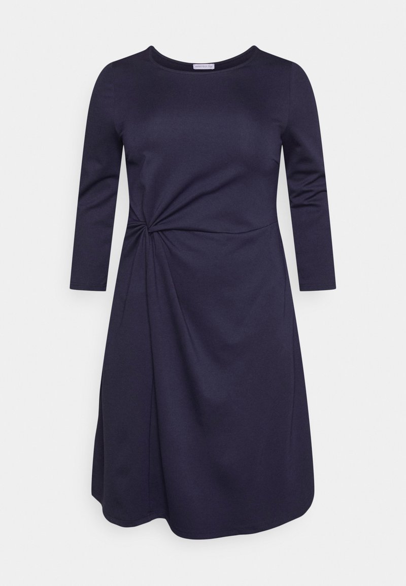 Robe bleu marine, longueur genou, manches trois-quarts, avec un détail torsadé à la taille et une texture de tissu lisse et douce.