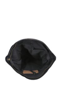 Black fabric bag interior with gold zipper, multiple pockets, and a leather tag; smooth texture, spacious design, and dark lining.