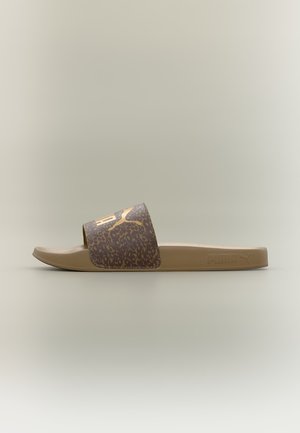 Enkelt brun Puma slidesandal med leopardmønstret strop og gyldent Puma-logo på beige baggrund.