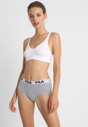 Bijela bralette s izrezom u obliku scoop, u kombinaciji s sivim hipster gaćicama koje imaju bijeli elastični pojas s crvenim i plavim Fila logotipom.