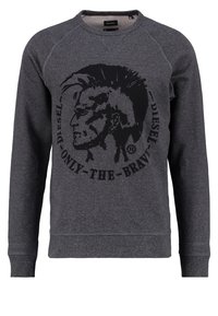 Grå sweatshirt gjord av texturerad tyg, med en stor svart grafisk tryck av en profil med mohawk och cirkulär text.