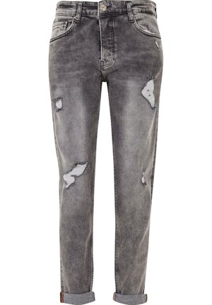 Szare, wysłużone jeansy z dziurami, z wyblakłą teksturą, pięcioma kieszeniami i zrolowanymi mankietami u dołu, co nadaje im zwężony wygląd.
