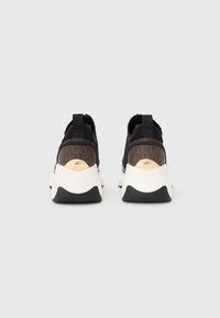 Sneakers in tessuto nero con dettagli a contrasto marroni e suole bianche. Presentano un dettaglio in hardware dorato sul retro e un design texturizzato.