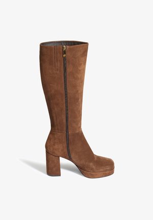 Brązowy zamszowy bot na wysokości kolana z grubym słupkowym obcasem, z bocznym zamkiem błyskawicznym i gładkim wnętrzem.