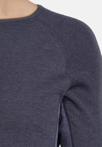 Granatowy sweter wełniany z okrągłym dekoltem, rękawami typu raglan i teksturowanym materiałem. Posiada subtelne poziome paski i boczny wentyl.