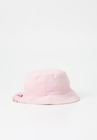 Rosa bucket hat tillverkad av mjukt tyg. Har en rund topp och en bred, fladdrig skärm. Sömdetaljer synliga på sidorna.