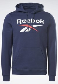 Marineblå sweatshirt med en frontlomme, justerbar hætte og et stort hvidt Reebok-logo med røde accenter. Blødt bomuldsblandingsstof.