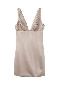 Vestido sin mangas con un escote en V profundo, cuerpo texturizado en color beige adornado con pequeñas embellissements, falda fluida y suave, de longitud hasta la rodilla.