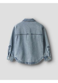 Gaiši zilas džinsa krekls, brīva piegriezuma, ar garām piedurknēm un pogājamiem manšetēm, salocītu apkakli un detaļām muguras daļā. Gluda tekstūra, ikdienišķs dizains.