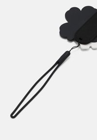 Svart skyformet merke laget av mykt materiale, med et svart bånd som har et glatt grep. Inkluderer en løkke for feste.
