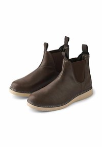 Botas de tobillo de cuero marrón con paneles elásticos, lengüetas y una suela de goma beige. Presenta un detalle de costura a contraste a lo largo del borde de la suela.