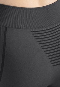 Sorte atletikleggings med ribbet taljebånd, tekstureret stof og vandret stribet mønster på den ene side. Glat finish.