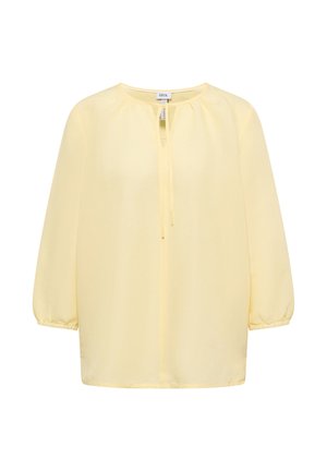 Lichtgele blouse met lange mouwen, ronde hals, strikdetail aan de voorkant en elastische manchetten van het merk Cecil, weergegeven op een witte achtergrond.