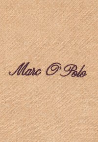 Un tissu beige à tissage texturé présente le nom "Marc O'Polo" brodé en script violet foncé.