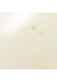 Glatte, glänzende Oberfläche in einem hellen Cremeton mit kleinen, runden Bläschen und Texturen, die einen subtilen Glanz-Effekt erzeugen.