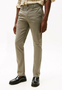 Slim-fit broeken van lichtgrijze stof, met een subtiel patroon, een platte voorkant, riemlussen en zijzakken, in combinatie met zwarte instappers.