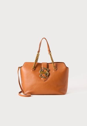 Bruine leren handtas met gouden kettinghandvatten en een decoratief gouden slangembleem op de sluitingstrap aan de voorkant.