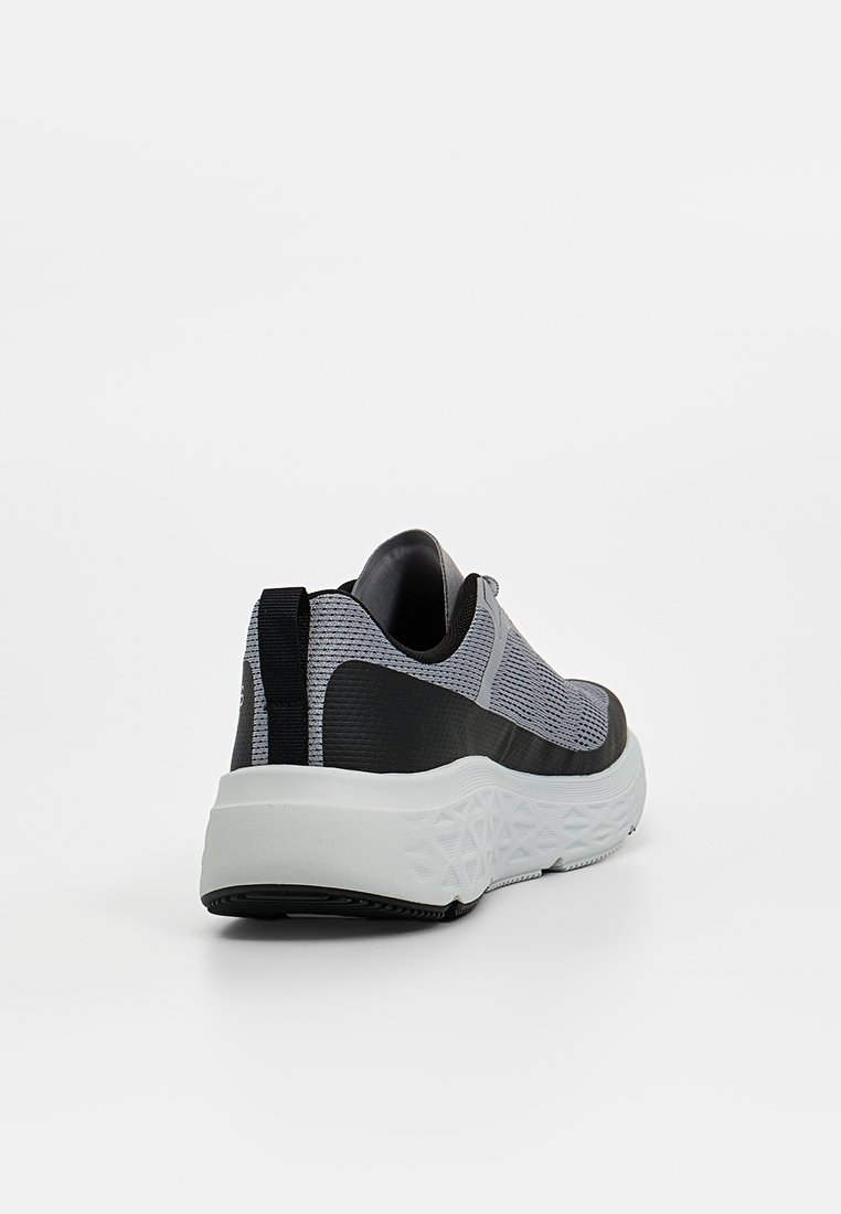 Zapatilla deportiva en gris y negro con parte superior de malla texturizada, suela blanca acolchada y una lengüeta en el talón para facilitar su uso.